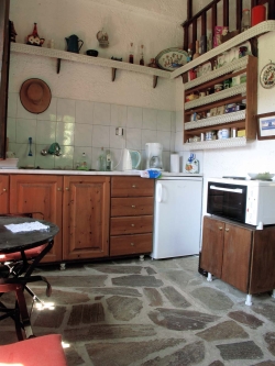 vaste cuisine avec étagère traditionnelle, four et 3 plaques électriques.
